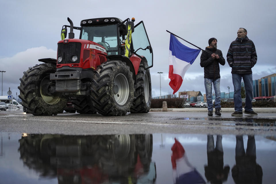 Protesters prepare to leave for a convoy in Lyon, central France, Friday, Feb.11, 2022. Authorities in France and Belgium have banned road blockades threatened by groups organizing online against COVID-19 restrictions. The events are in part inspired by protesters in Canada. Citing "risks of trouble to public order," the Paris police department banned protests aimed at "blocking the capital" from Friday through Monday. (AP Photo/Laurent Cipriani)