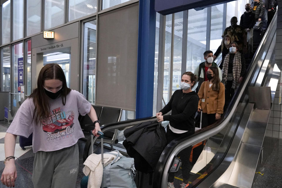 Travelers walk through Terminal 1 at O'Hare International Airport in Chicago, Thursday, Dec. 30, 2021. (AP Photo/Nam Y. Huh)