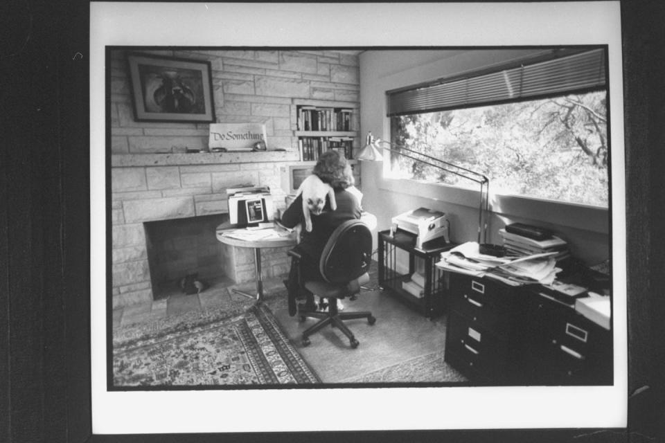 Rear view of newspaper columnist Molly Ivins working at a computer as her pet Siamese cat hangs over one shoulder in her office. <a href="https://www.gettyimages.com/detail/news-photo/rear-view-of-newspaper-columnist-molly-ivins-working-at-news-photo/50469187?adppopup=true" rel="nofollow noopener" target="_blank" data-ylk="slk:Mark Perlstein/Getty Images;elm:context_link;itc:0;sec:content-canvas" class="link ">Mark Perlstein/Getty Images</a>