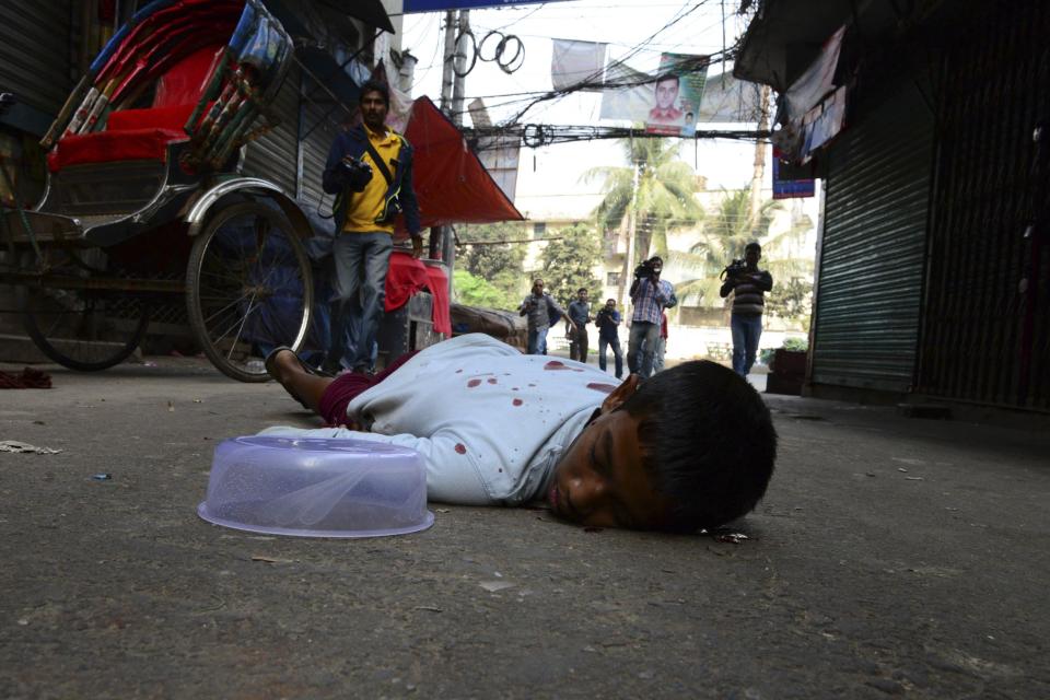 A boy lies on the ground after being injured by rubber bullets fired by police during clashes between Bangladesh's Jamaat-e-Islami party activists and police in Dhaka