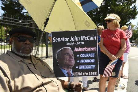 Aug 12, 2018; Annapolis, MD, USA; Charles James Sr. sits with a sign he made to watch the passing of John McCain's motorcade on his way to be laid to rest at the U.S. Naval Academy. Mandatory Credit: Jasper Colt via USA TODAY NETWORK
