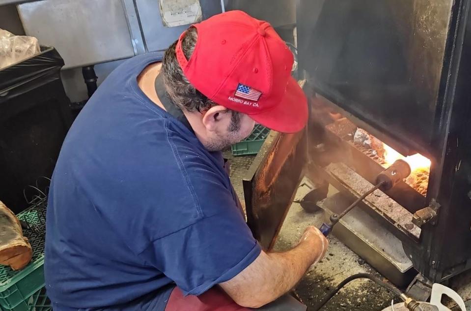 Miguel Fuentes, owner/partner at Los Morros BBQ in Morro Bay, mans his new Backwoods Smoker, which he stokes with red oak wood. He then finishes off the smoked meat by glazing it with a pro propane torch.