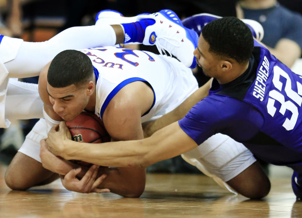 Kansas forward Landen Lucas (33) and TCU forward Karviar Shepherd (32) go to the floor for the ball during first half of an NCAA college basketball game in the quarterfinal round of the Big 12 tournament in Kansas City, Mo., Thursday, March 9, 2017. (AP Photo/Orlin Wagner)