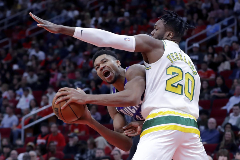 Milwaukee Bucks forward Giannis Antetokounmpo, left, looks to get around Houston Rockets forward Bruno Fernando (20) during the second half of an NBA basketball game Sunday, Dec. 11, 2022, in Houston. (AP Photo/Michael Wyke)