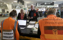 Foreign tourists wait to be checked by German Embassy staff at Christchurch Airport terminal as they prepare to check in for a charter flight back to Germany via Vancouver from Christchurch, New Zealand, Monday, April 6, 2020. The German Embassy in Wellington last week said more than 12,000 German tourists had signed up for its repatriation program from New Zealand following the strict monthlong lockdown, which is aimed at preventing more coronavirus infections. The new coronavirus causes mild or moderate symptoms for most people, but for some, especially older adults and people with existing health problems, it can cause more severe illness or death. (AP Photo/Mark Baker)