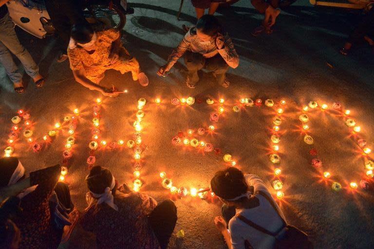 Cambodian residents light candles as they pray for the missing Malaysia Airlines flight MH370 at their village in Phnom Penh on March 17, 2014