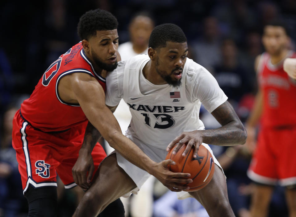 St. John's guard LJ Figueroa, left, knocks the ball from the hands of Xavier forward Naji Marshall (13) during the second half of an NCAA college basketball game, Sunday, Jan. 5, 2020, in Cincinnati. (AP Photo/Gary Landers)