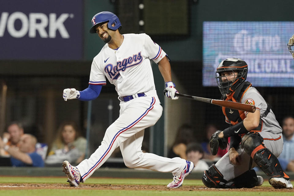 Texas Rangers' Marcus Semien, left, reacts to fouling off his leg in front of Baltimore Orioles catcher Anthony Bemboom during the third inning of a baseball game in Arlington, Texas, Monday, April 3, 2023. (AP Photo/LM Otero)