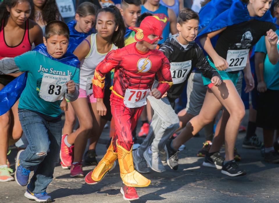 Dressed as the Flash, then-10-year-old Mario Franco of Stockton, center, takes off from the start of the Court Appointed Special Advocates (CASA) of San Joaquin's Superhero Run/Walk at Lodi Lake in Lodi on Oct. 7, 2017.