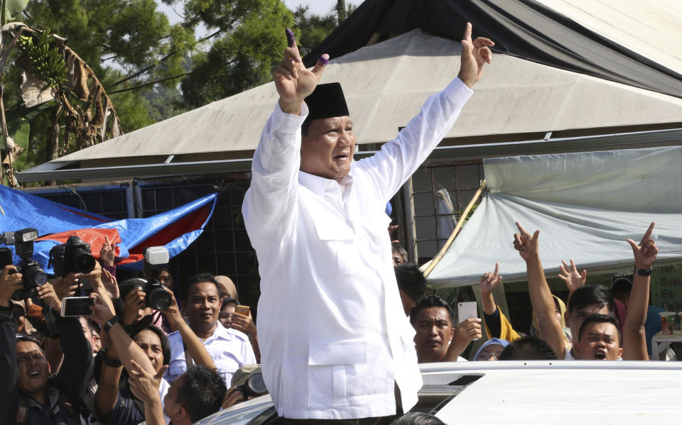 Indonesian presidential candidate Prabowo Subianto greets to his supporters after casting his vote at a polling station in Bogor, Indonesia, Wednesday, April 17, 2019. Tens of millions of Indonesians were voting in presidential and legislative elections Wednesday after a campaign that pitted the moderate incumbent against an ultranationalist former general whose fear-based rhetoric warned the country would fall apart without his strongman leadership. (AP Photo/Achmad Ibrahim)