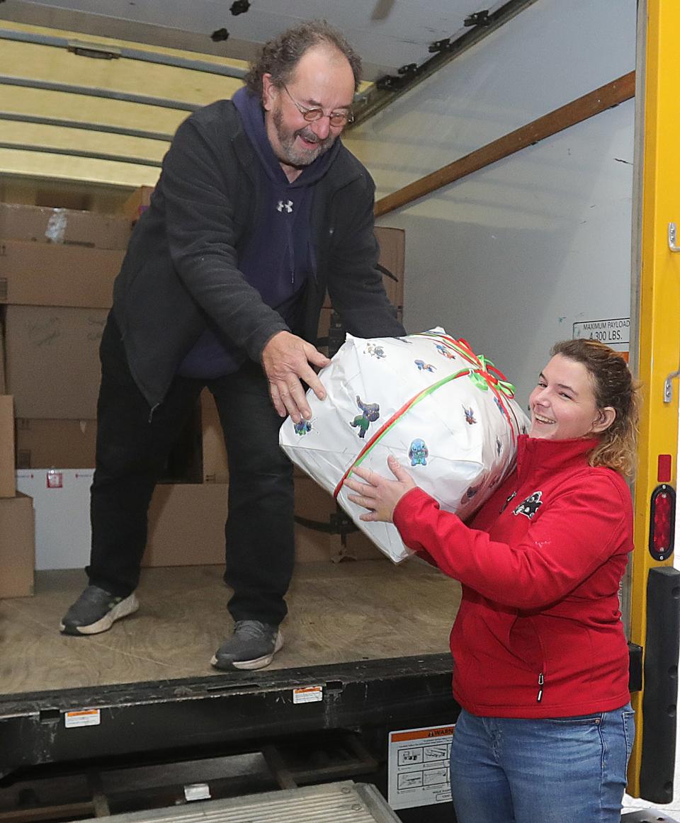 Lou Bogavich hands a box of toys from the Children's Toy Fund to Ashley Natale at Akron Children's Hospital on Tuesday.