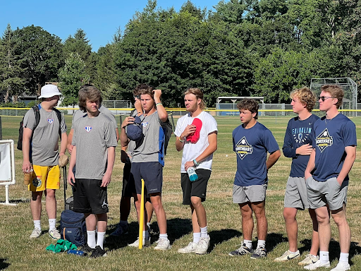 Players stand and remove their hats before the eighth annual Random Smiles Project Wiffle Ball Tournament. Players pictured include Franklin baseball’s James Kuczmiec (white shirt), Jacob Crisileo (hands behind back) and Chris Goode (hands in pocket).