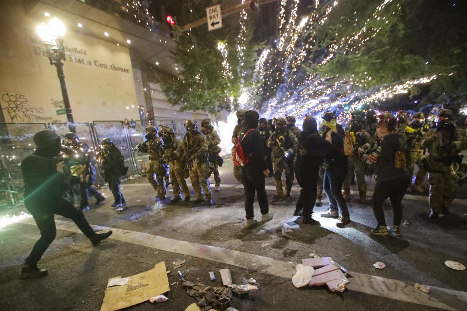 Federal officers advance on demonstrators during a Black Lives Matter protest at the Mark O. Hatfield United States Courthouse Saturday, July 25, 2020, in Portland, Ore. (AP Photo/Marcio Jose Sanchez)