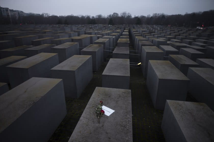 Roses with a note saying "#weremember", are placed on the Holocaust Memorial on International Holocaust Remembrance Day, in Berlin, Germany, Wednesday, Jan. 27, 2021. (AP Photo/Markus Schreiber)