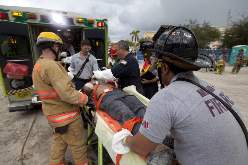 DORAL, FL - OCTOBER 10: In this handout from Miami-Dade Fire Rescue, Miami-Dade Fire Rescue workers place an injured person into an ambulance after pulling him from under the rubble of a four-story parking garage that was under construction and collapsed at the Miami Dade College's West Campus on October 10, 2012 in Doral, Florida. Early reports indicate that one person was killed, at least seven people injured and an unknown number of people may be buried in the rubble. (Photo by Miami-Dade Fire Rescue via Getty Images)