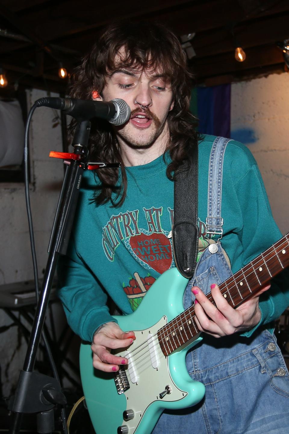 Jace Ludlum of the Red Shirts performs in Davey Grumbine's basement on Saturday, March 25, 2023. Grumbine's house is one of several do-it-yourself house venues in Springfield.