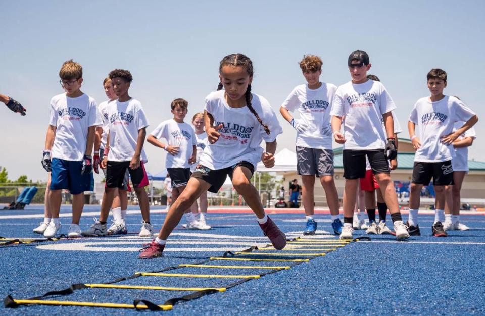 Eleven-year-old Cruz “Zone” runs through drills at the Bulldogs Back Home 2023 football camp on Saturday, June 17, 2023, at Folsom High School. NFL players and former Bulldogs Jack Browning, Josiah Deguara and Jonah Williams — along with former player Jordan Richards — worked alongside head coach Paul Doherty and other Folsom coaches at the camp.