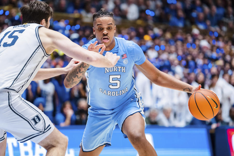 North Carolina forward Armando Bacot (5) drives to the basket while guarded by Duke center Ryan Young (15) in the first half of an NCAA college basketball game on Saturday, Feb. 4, 2023, in Durham, N.C. (AP Photo/Jacob Kupferman)