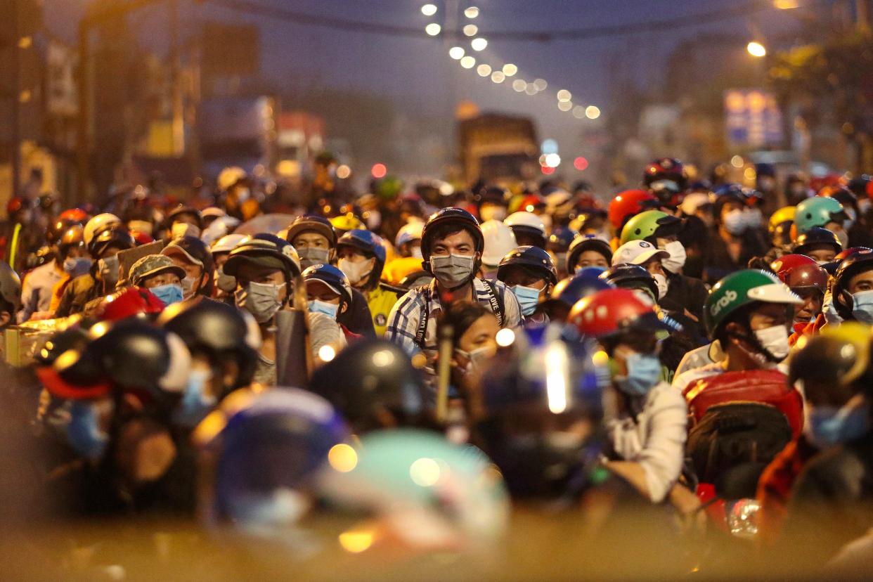 FILE PHOTO: People planning to return to their hometowns wait at a checkpoint to leave Ho Chi Minh City in the early hours of October 1, 2021, following the easing of strict Covid-19 coronavirus restrictions that had been in place for the past three months. (Photo: CHI PI/AFP via Getty Images)