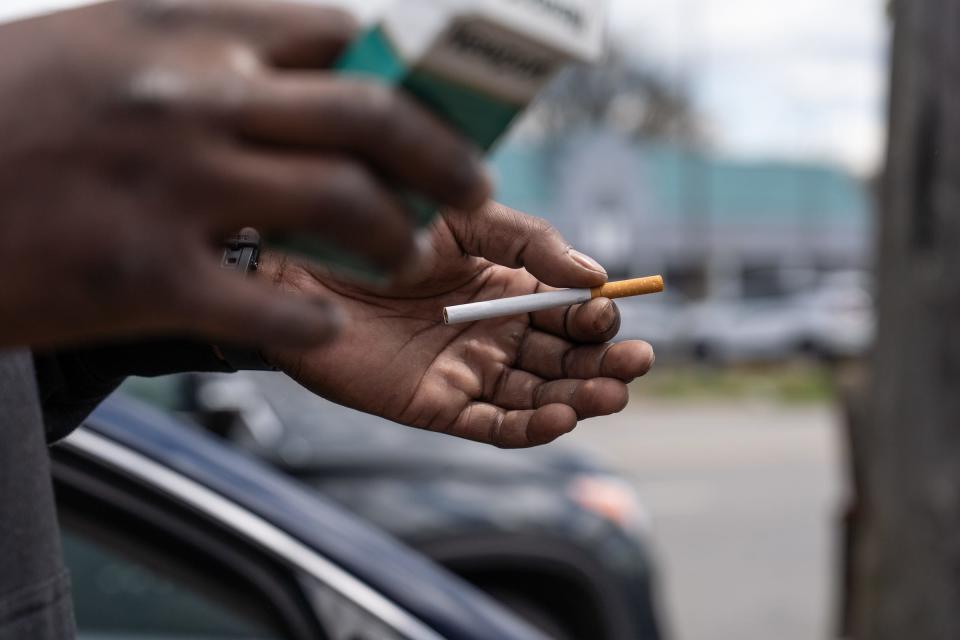 A man prepares to light a Newport 100 menthol cigarette outside of Big V Party Store on Greenfield Road in Detroit on April 30, 2021 while talking about the nationwide ban of menthol cigarettes aimed at protecting African Americans.