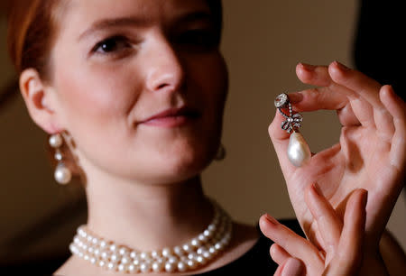 FILE PHOTO: A model holds a natural pearl and diamond pendant once owned by Marie Antoinette together with wearing a pair of natural drops and a necklace featuring 119 natural pearls during a press preview ahead of the upcoming auction "Royal jewels from the Bourbon Parma Family" at Sotheby's in Geneva, Switzerland November 7, 2018. REUTERS/Denis Balibouse/File photo
