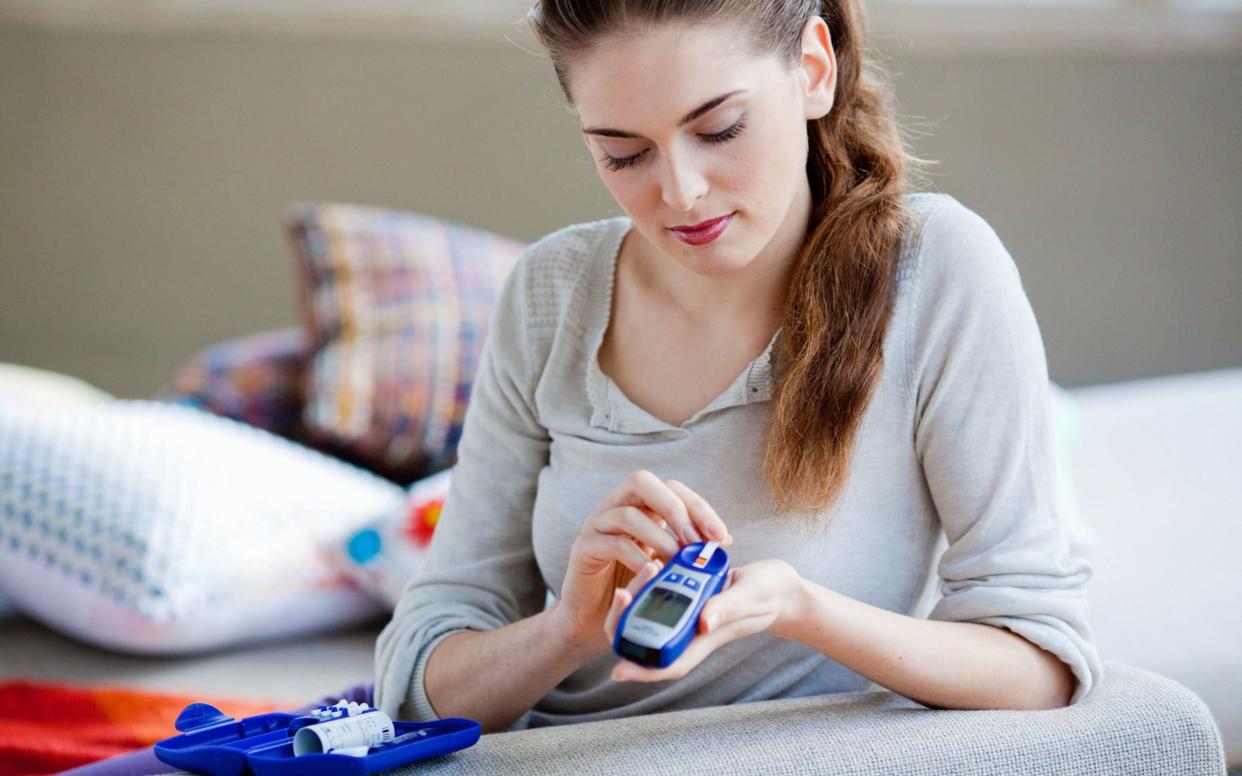 A woman checking her blood sugar level - Getty Images Contributor