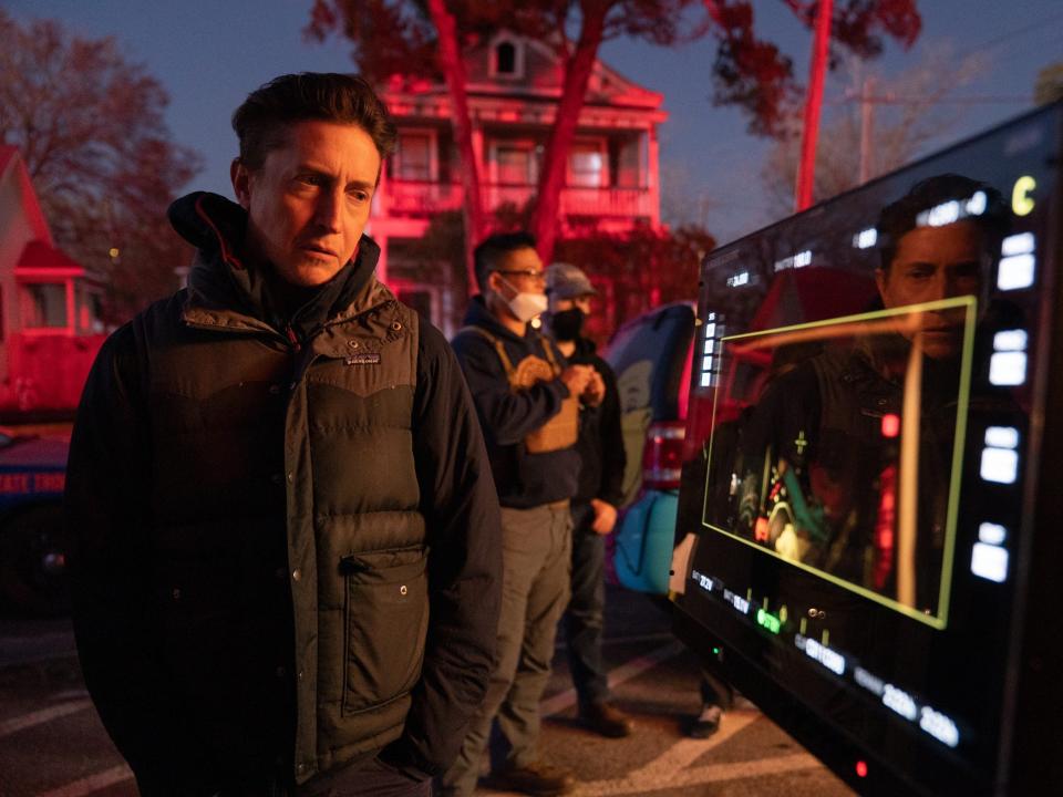 David Gordon Green in a vest on the set of Halloween Ends with a house in the background