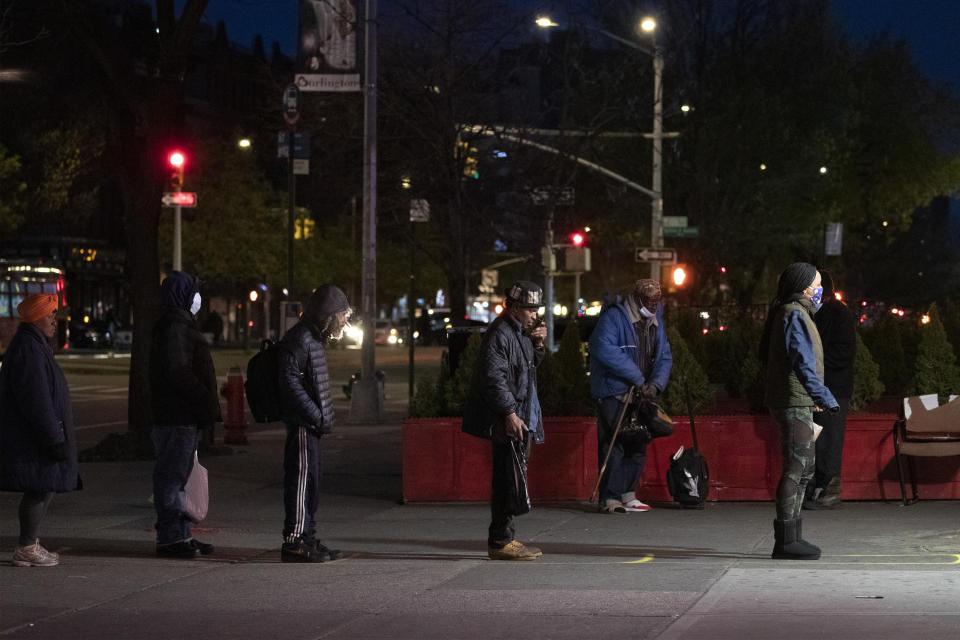 People maintain social distancing while waiting in line to enter a store Thursday, April 16, 2020, in the Harlem neighborhood of New York. The New York City immortalized in song and scene has been swapped out for the last few months with the virus version. In all the unknowing of what the future holds, there's faith in that other quintessential facet of New York City: that the city will adapt. (AP Photo/Mark Lennihan)