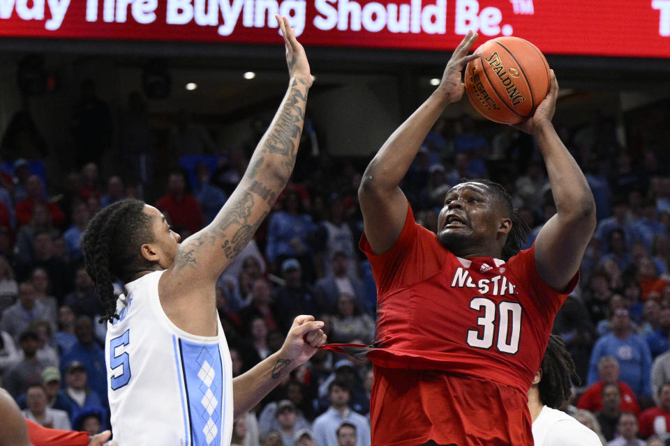 North Carolina State forward DJ Burns Jr. (30) taking a shot against North Carolina forward Armando Bacot (5) during the second half of an NCAA college basketball game in the championship of the Atlantic Coast Conference tournament, Saturday, March 16, 2024, in Washington. (AP Photo/Nick Wass)