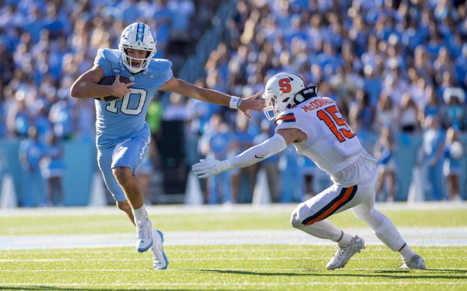 North Carolina quarterback Drake Maye (10) breaks away from Syracuse’s Derek McDonald (15) for a 12-yard gain in the second quarter on Saturday, October 7, 2023 at Kenan Stadium in Chapel Hill, N.C.