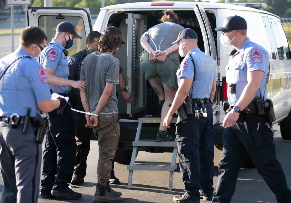 Raleigh police officers load the last of the nearly 18 protesters that were arrested for blocking traffic on Capital Blvd. near the Peace Street bridge on Thursday, July 2, 2020 in Raleigh, N.C.