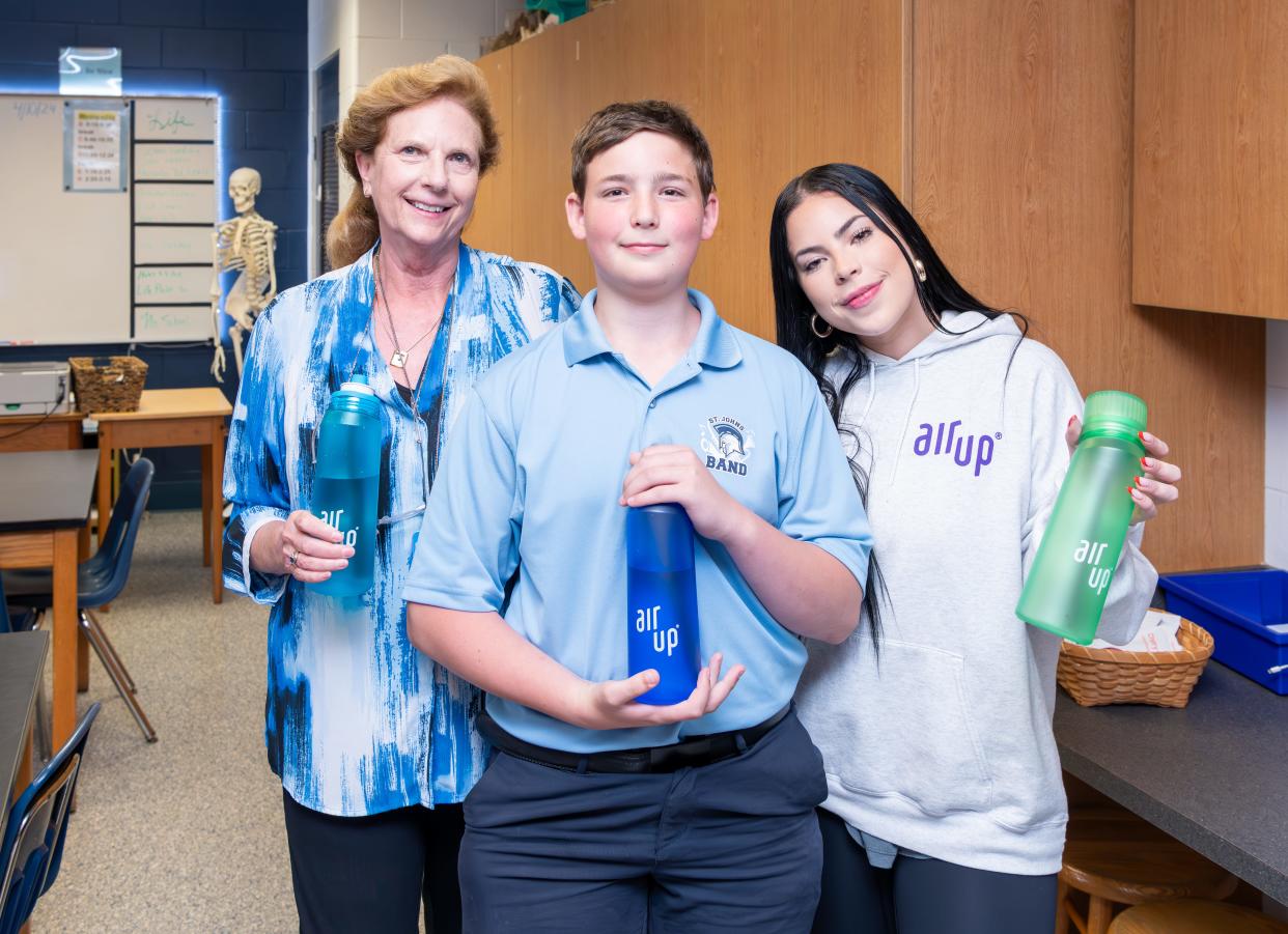 St. Johns Country Day School sixth-grader Grayson Kalch and his science teacher Tina Sachs post with air up representative Natalia Martinez and water bottles that are part of the company's scent-taste technology. Grayson contacted the company for a science project.