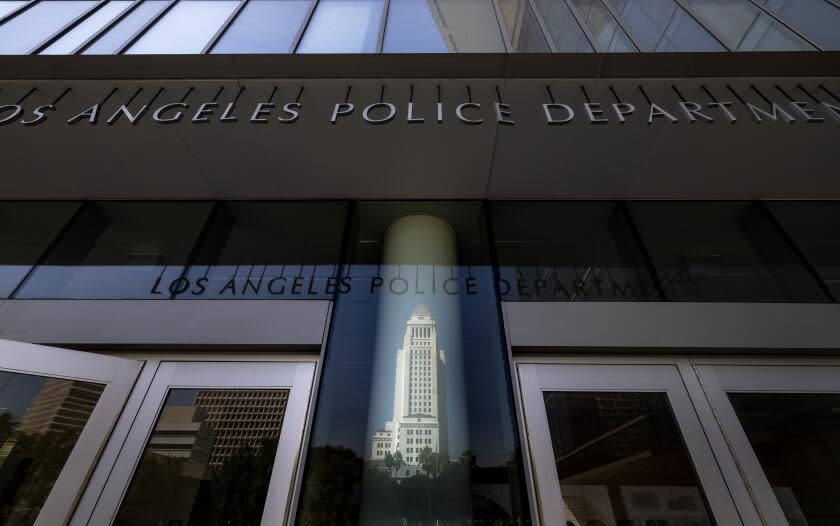 Los Angeles, CA - September 26: Los Angeles City Hall tower is reflected above the entrance to LAPD Headquarters in downtown Los Angeles on Tuesday, Sept. 26, 2023 in Los Angeles, CA. (Brian van der Brug / Los Angeles Times)