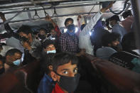 In this Friday, March 27, 2020, file photo, migrant daily wage laborers crowd a bus as they travel to their respective hometowns following a lockdown amid concern over spread of coronavirus in New Delhi, India. Over the past week, India’s migrant workers - the mainstay of the country’s labor force - spilled out of big cities that have been shuttered due to the coronavirus and returned to their villages, sparking fears that the virus could spread to the countryside. It was an exodus unlike anything seen in India since the 1947 Partition, when British colothe subcontinent, with the 21-day lockdown leaving millions of migrants with no choice but to return to their home villages. (AP Photo/Manish Swarup, File)