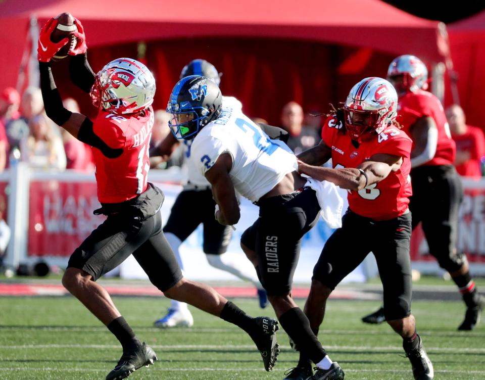 Western defensive back Kahlef Hailassie (12) intercepts the ball intended for MTSU wide receiver Izaiah Gathings (2) as he looks on and Western defensive end Michael Pitts (43) holds him back on Saturday, Nov. 6, 2021, at Houchens-Smith Stadium, in Bowling Green, Ky.<br>© HELEN COMER/The Daily News Journal