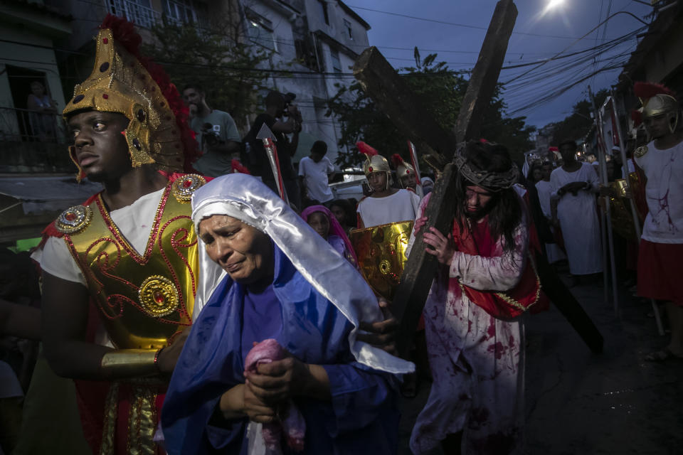 A woman, playing the role of Jesus Christ's mother, sheds tears during a Way of the Cross reenactment as part of Holy Week celebrations, at the Complexo do Alemao favela in Rio de Janeiro, Brazil, Friday, March 29, 2024. Holy Week commemorates the last week of Jesus Christ's earthly life which culminates with his crucifixion on Good Friday and his resurrection on Easter Sunday. (AP Photo/Bruna Prado)