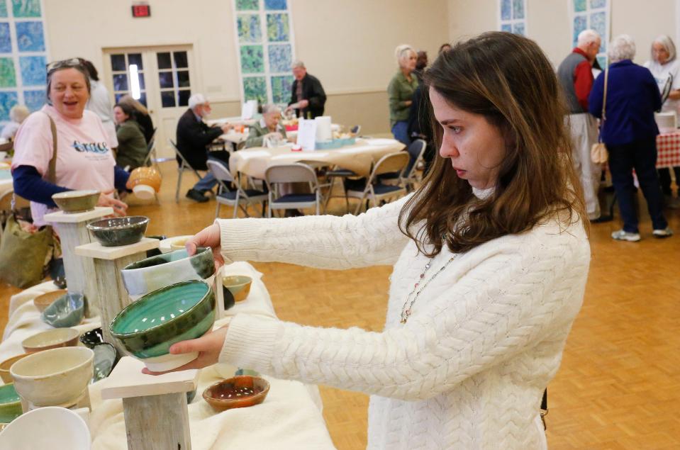 Marilia Lara selects a hand-crafted bowl during Grace Presbyterian Church's Empty Bowls fundraiser in this March 6, 2020, file photo.