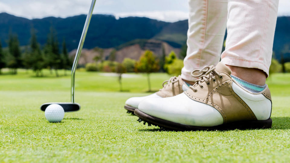 Golf player hitting a ball at the putting green - Image.