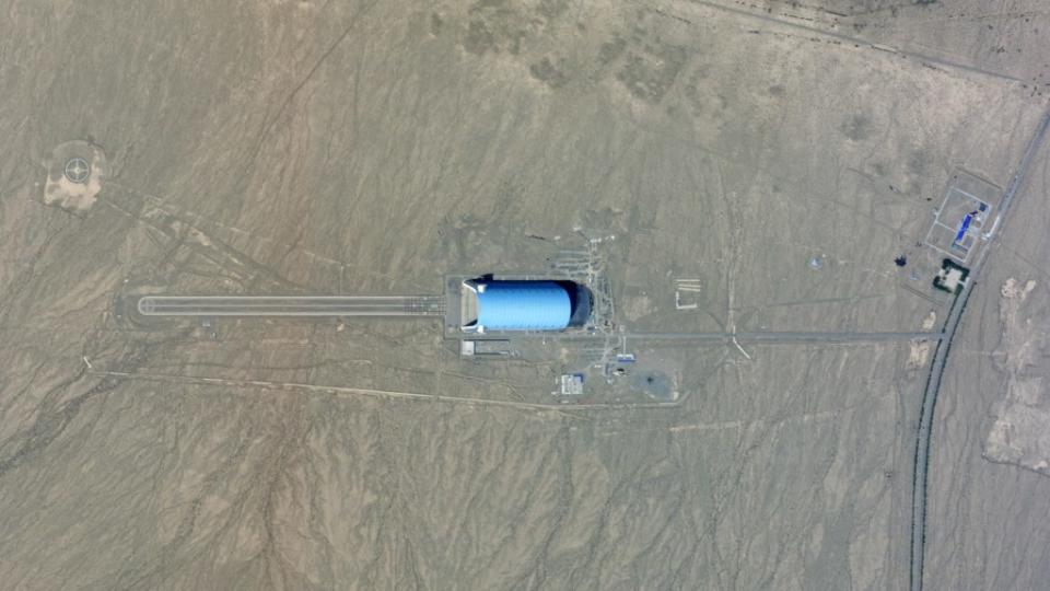 A high-resolution satellite image of the hangar taken on June 7, 2024, showing the extension under construction. This oblique view also shows the main door open and gives a good sense of how tall the structure is. <em>PHOTO © 2024 PLANET LABS INC. ALL RIGHTS RESERVED. REPRINTED BY PERMISSION</em>