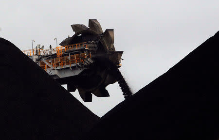 FILE PHOTO: A reclaimer places coal in stockpiles at the coal port in Newcastle June 6, 2012. REUTERS/Daniel Munoz/File Photo