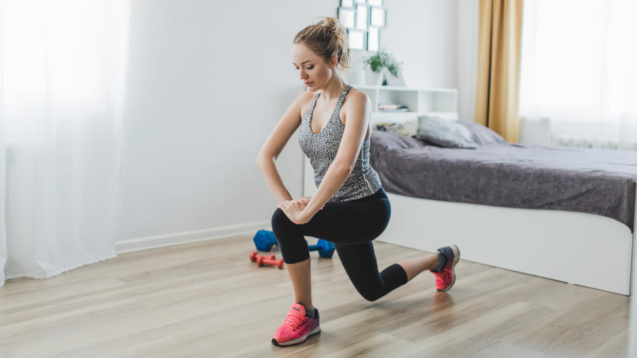  Woman doing bodyweight lunges in her bedroom 