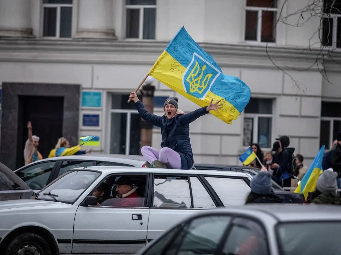 Local residents celebrate after Russia's retreat from Kherson, the only provincial capital captured by Moscow. (Yevhenii Zavhorodnii/Reuters - image credit)