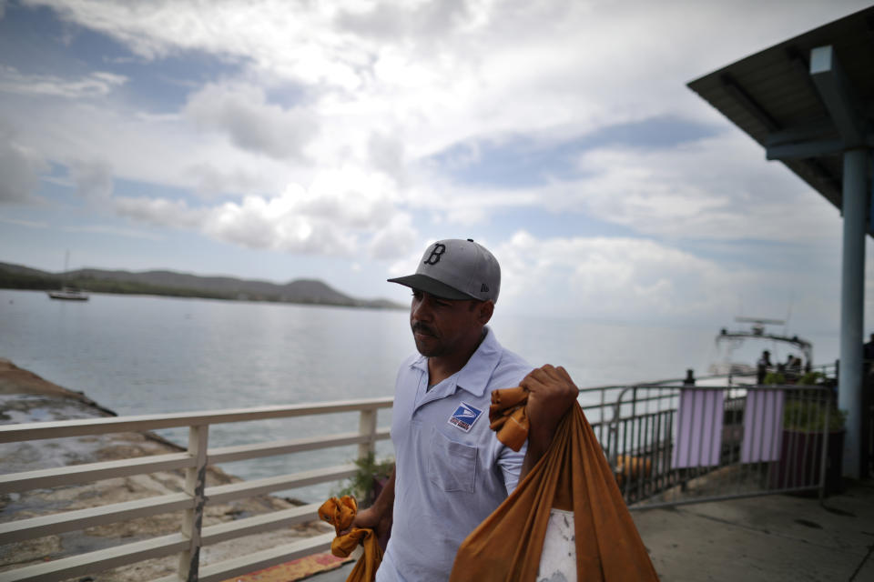 <p>Luis Menendez, a mail man for the U.S. Postal Service, receives mail by boat at a narea affected by Hurricane Maria in the island of Vieques, Puerto Rico, Oct. 7, 2017. (Photo: Carlos Barria/Reuters) </p>