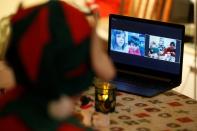 Children are seen on a screen as Santa interacts with them by video, amid the COVID-19 outbreak in Budapest