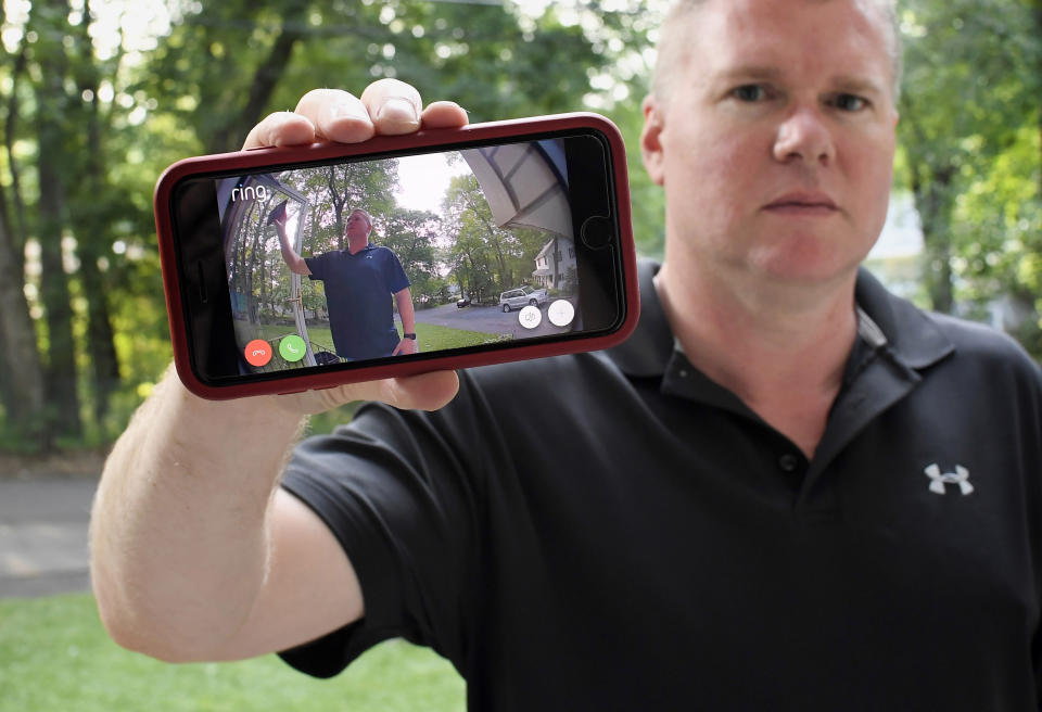 In this Tuesday, July 16, 2019, photo, Ernie Field holds up a live video of himself taken by a Ring doorbell camera at the front door at his home in Wolcott, Conn. Field won a free Ring camera and said he had to register for the app to qualify for the raffle. Now he gets alerts on his phone when a car drives by and a 30-second video when his daughter gets home from school. (AP Photo/Jessica Hill)