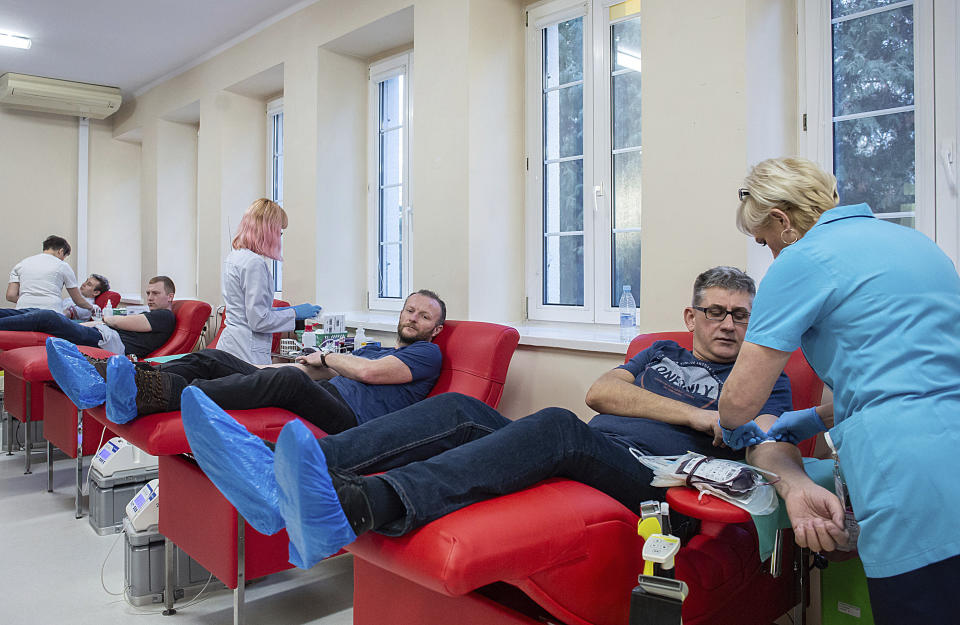 People donate blood for Gdansk Mayor Adamowicz, who is in critical condition and needs blood transfusions after being stabbed in the heart and abdomen on stage during a charity event the evening before, in Gdansk, Poland, Monday Jan. 14, 2019. Doctors operated for five hours on Adamowicz after an ex-convict rushed onto the stage with a knife, carried out the attack and shouted it was political revenge against a political party Adamowicz previously belonged to. (Krzysztof Mystkowski / KFP via AP) POLAND AUT