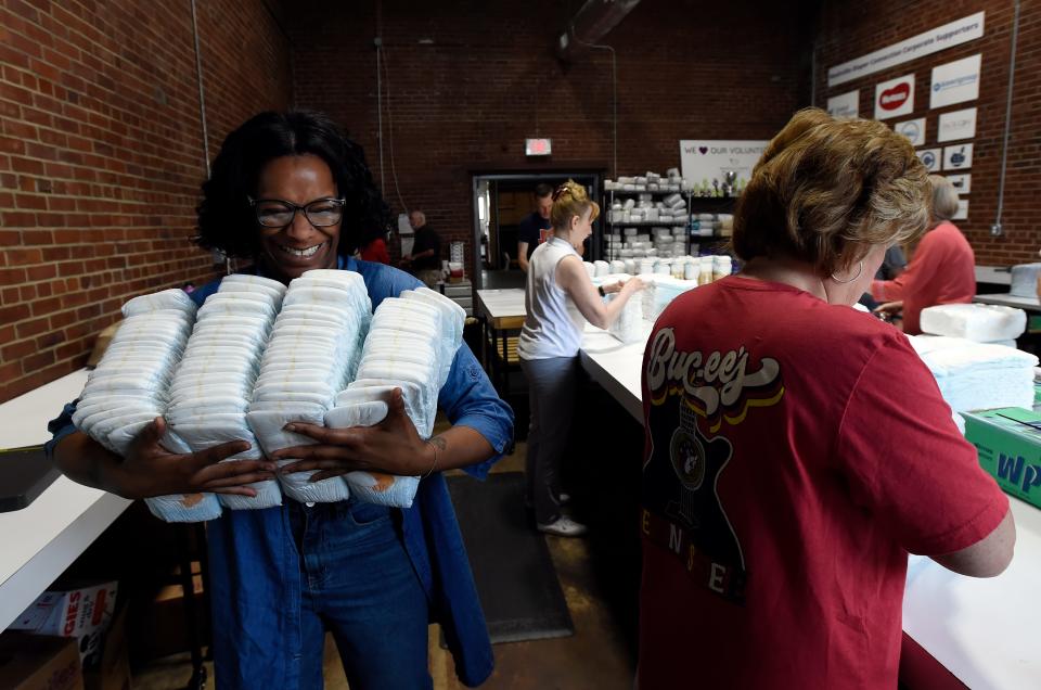 Diaper Connection employee and volunteer recruiter Renee Watkins carries diapers to be packaged at the Nashville Diaper Connection warehouse May 15 in Nashville. Tennessee could soon become the first state in the nation to offer two years of free diapers to low-income mothers on TennCare, the state’s Medicaid program. Funding for the program was included in Gov. Bill Lee’s budget for the fiscal year starting July 1. The Nashville Diaper Connection is a nonprofit that has been working to provide free diapers to help families before the state funding was available.