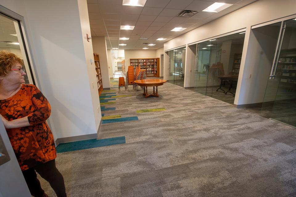 Library Director Mina Edmondson looks back at what will become sound studios in the Teens area of Martin Library.
