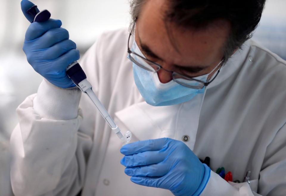 A lab assistant uses a pipette to prepare Coronavirus RNA for sequencing at the Wellcome Sanger Institute that is operated by Genome Research in Cambridge. Britain is a world leader in rapidly analyzing the genetic material from large numbers of COVID-19 infections.