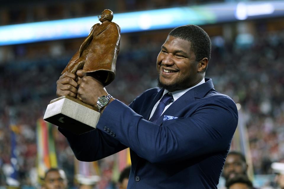 Jacksonville Jaguars' Calais Campbell raises the Walter Payton NFL Man of the Year trophy before the first half of the NFL Super Bowl 54 football game Sunday, Feb. 2, 2020, in Miami Gardens, Fla. (AP Photo/David J. Phillip)